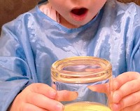 Amazed girl holding an inverted glass of coloured water