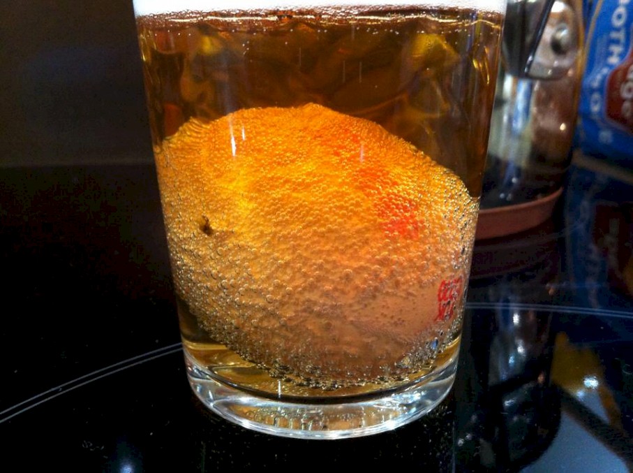 Egg covered in tiny bubbles in a glass of liquid